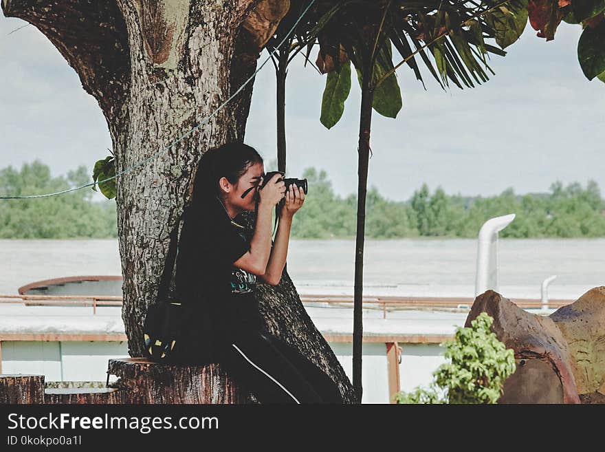 Woman Taking Photo Near to Tree