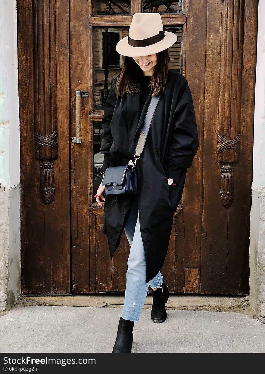 Photo of Woman Wearing Black Coat and Faded Blue Jeans