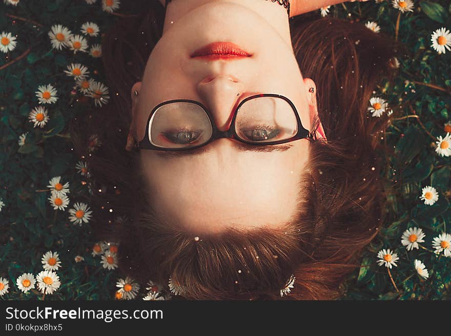 Woman Wearing Eyeglasses Lying On Grass