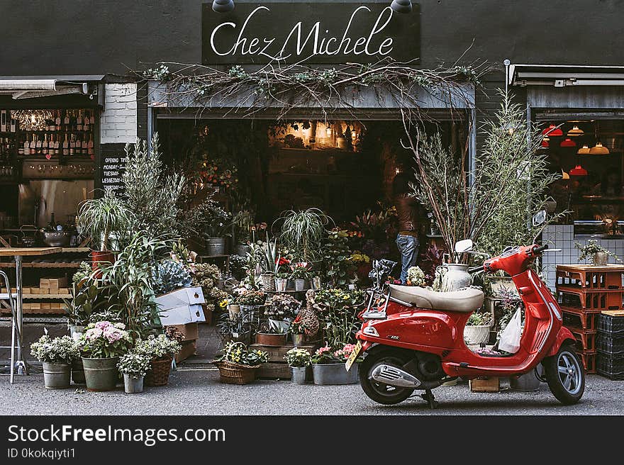 Red Motor Scooter Parking on Front of Chez Michele Store