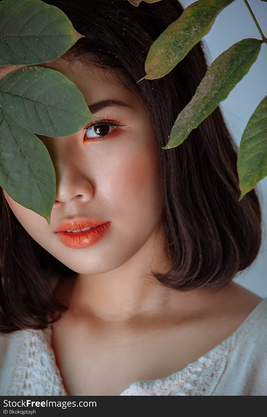 Photography Of Woman Hiding Behind Leaves