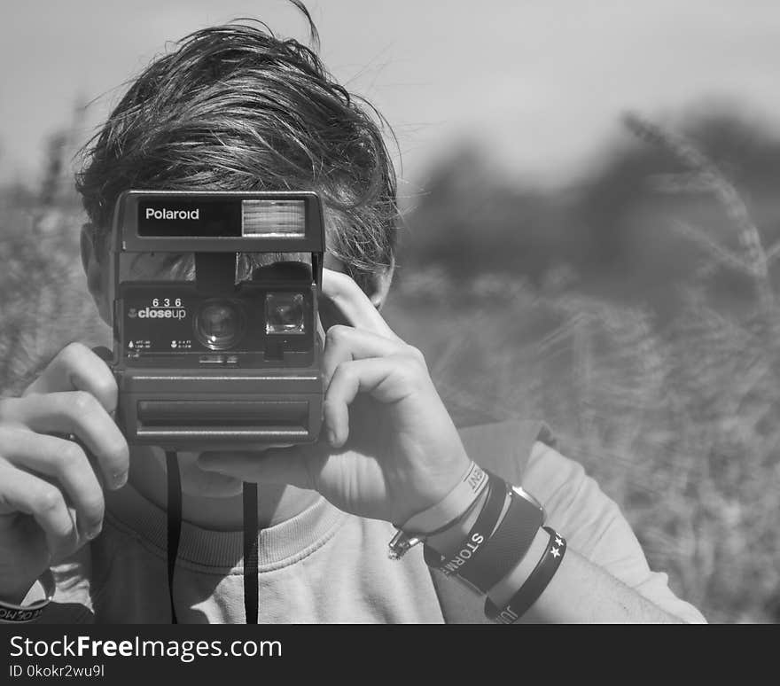 Photo of Person Holding Polaroid Camera