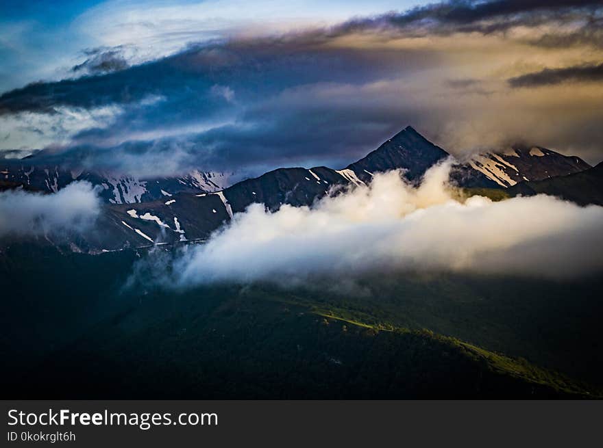 Cumulus Clouds Over Mountain Peak