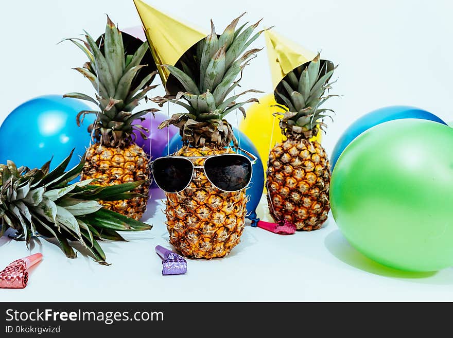 Photo Of Three Pineapples Surrounded By Balloons