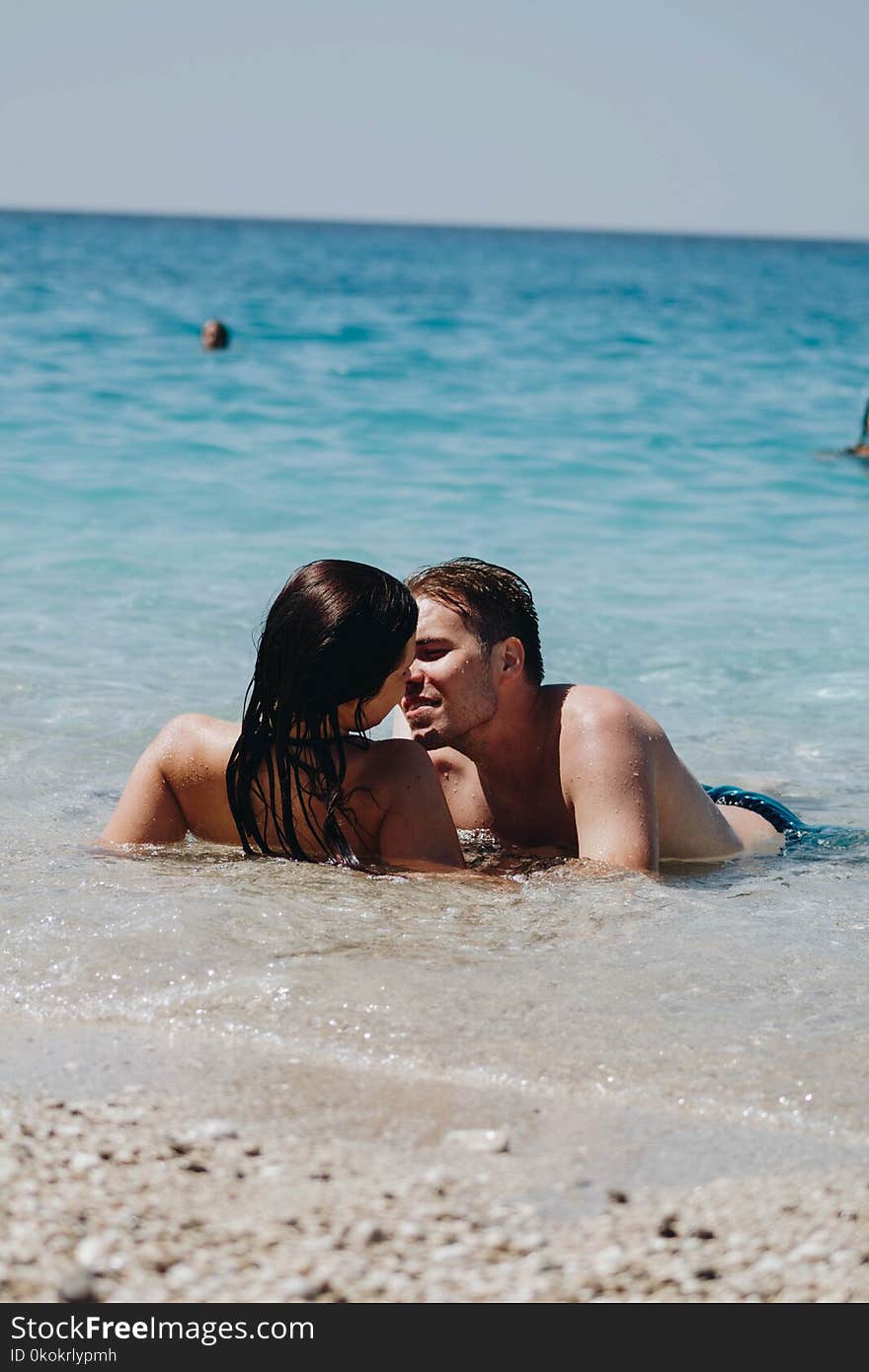 Photo of Man Kissing Woman on Seashore