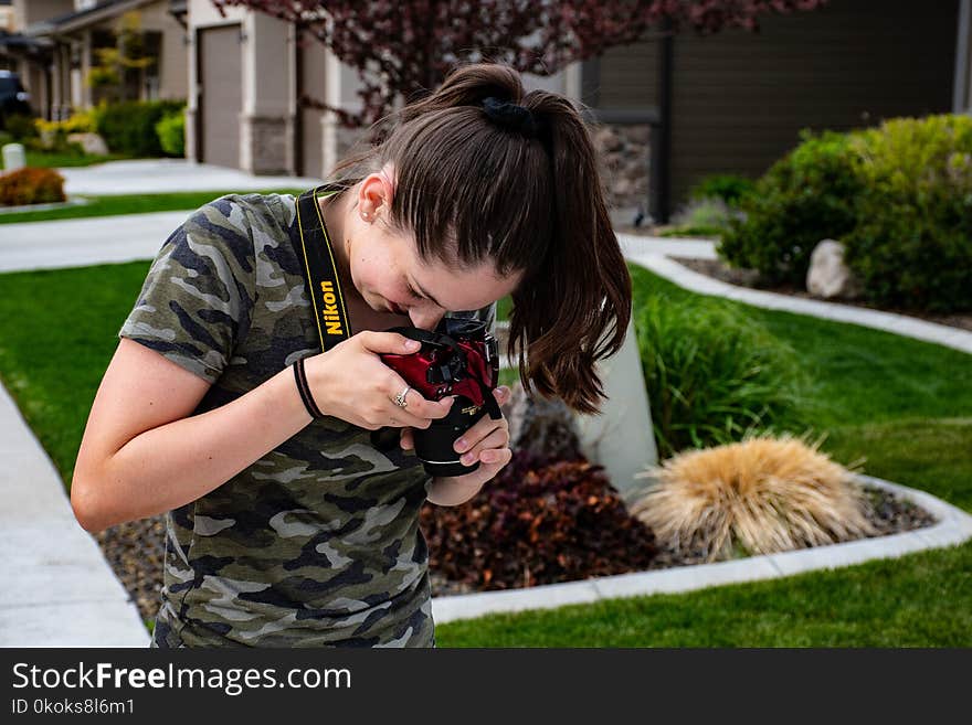 Woman Taking a Picture of Floor Using Nikon Camera