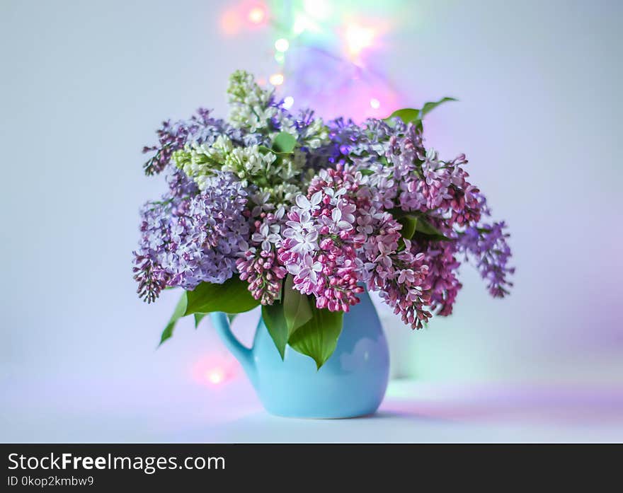 Beautiful Bouquet Of Fragrant Purple Flowers In Blue Ceramics Vase On Light Background. Syringa Vulgaris Or Lilacs Plant.