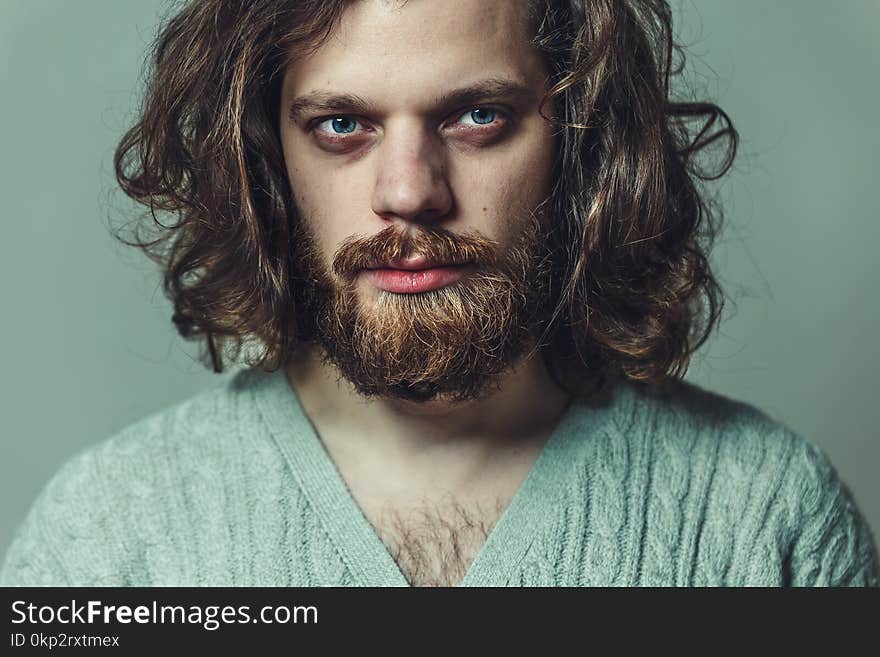 Handsome man with a beard and long hair. Creative portrait