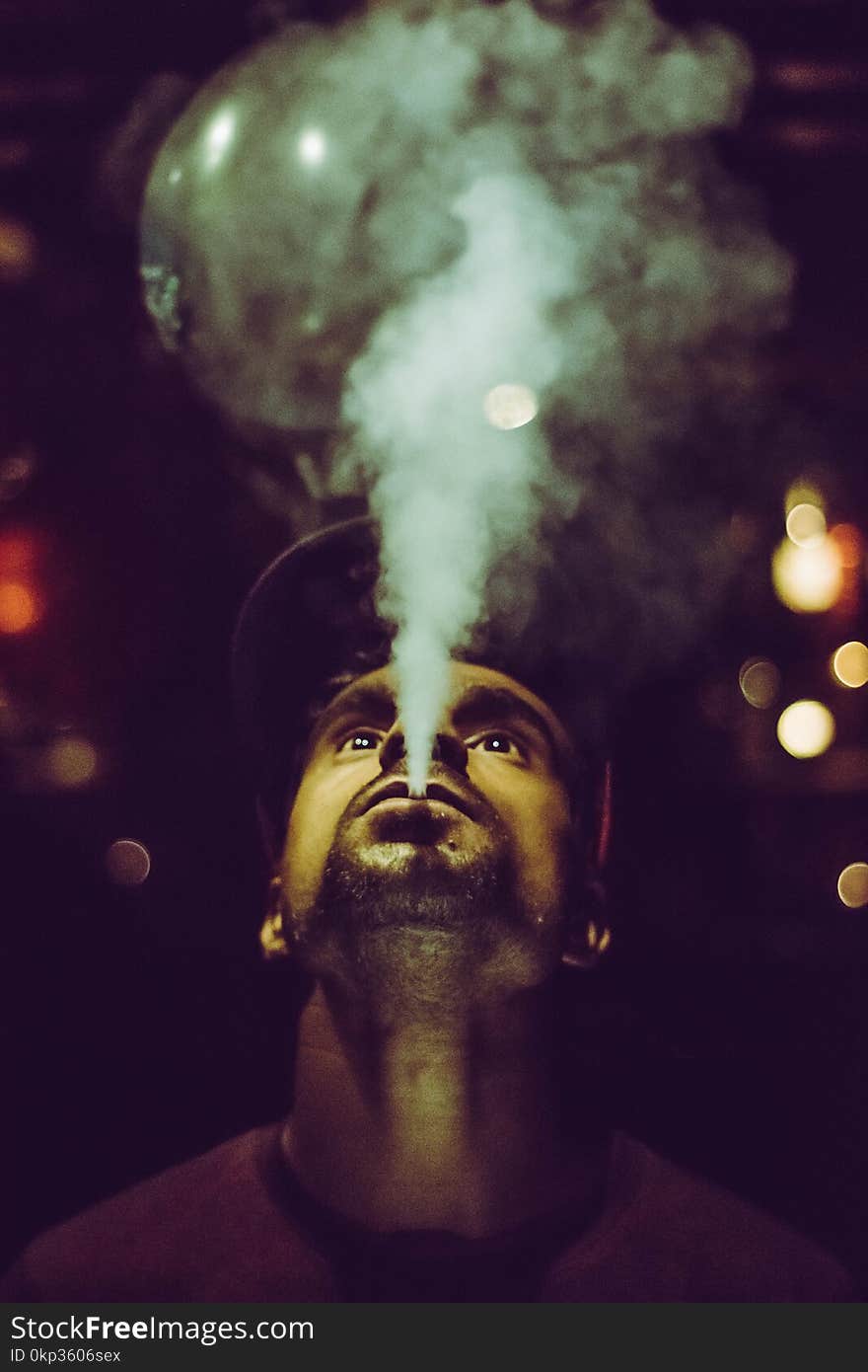 Man Wearing Crew-neck Shirt and Fitted Cap Smoking