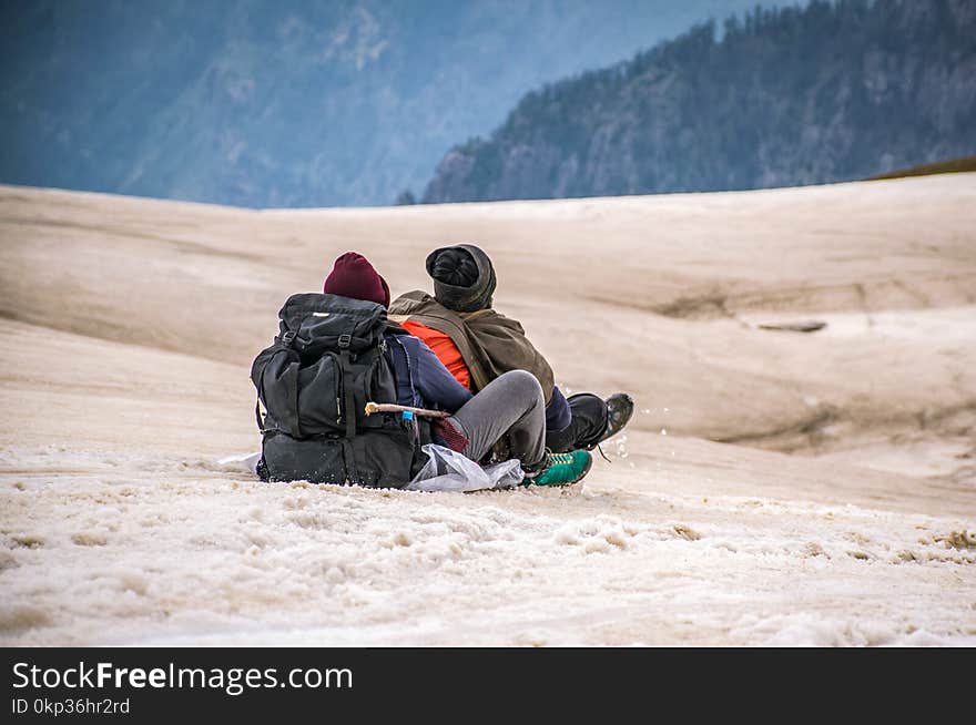 Two People Riding in Sled on Snow