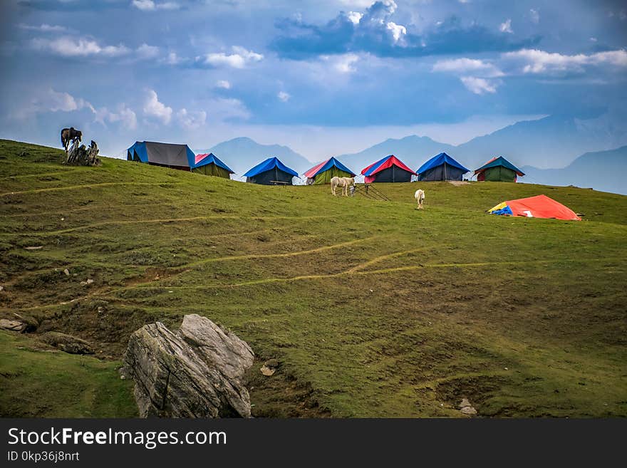 Photographed of Lined Tents on Green Grass Hills