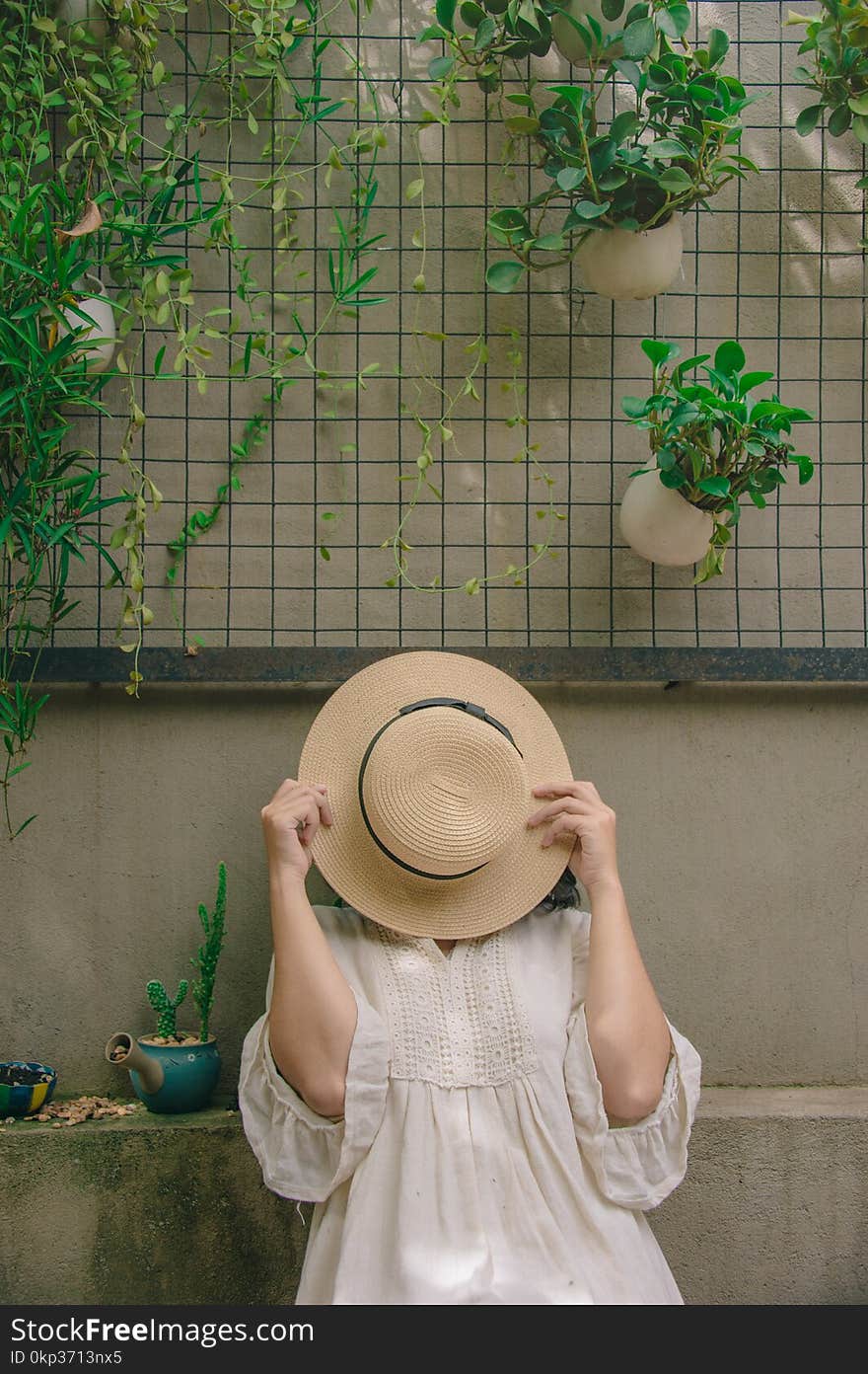 Person Wearing White Elbow-sleeved Top Covering Beige Sun Hat