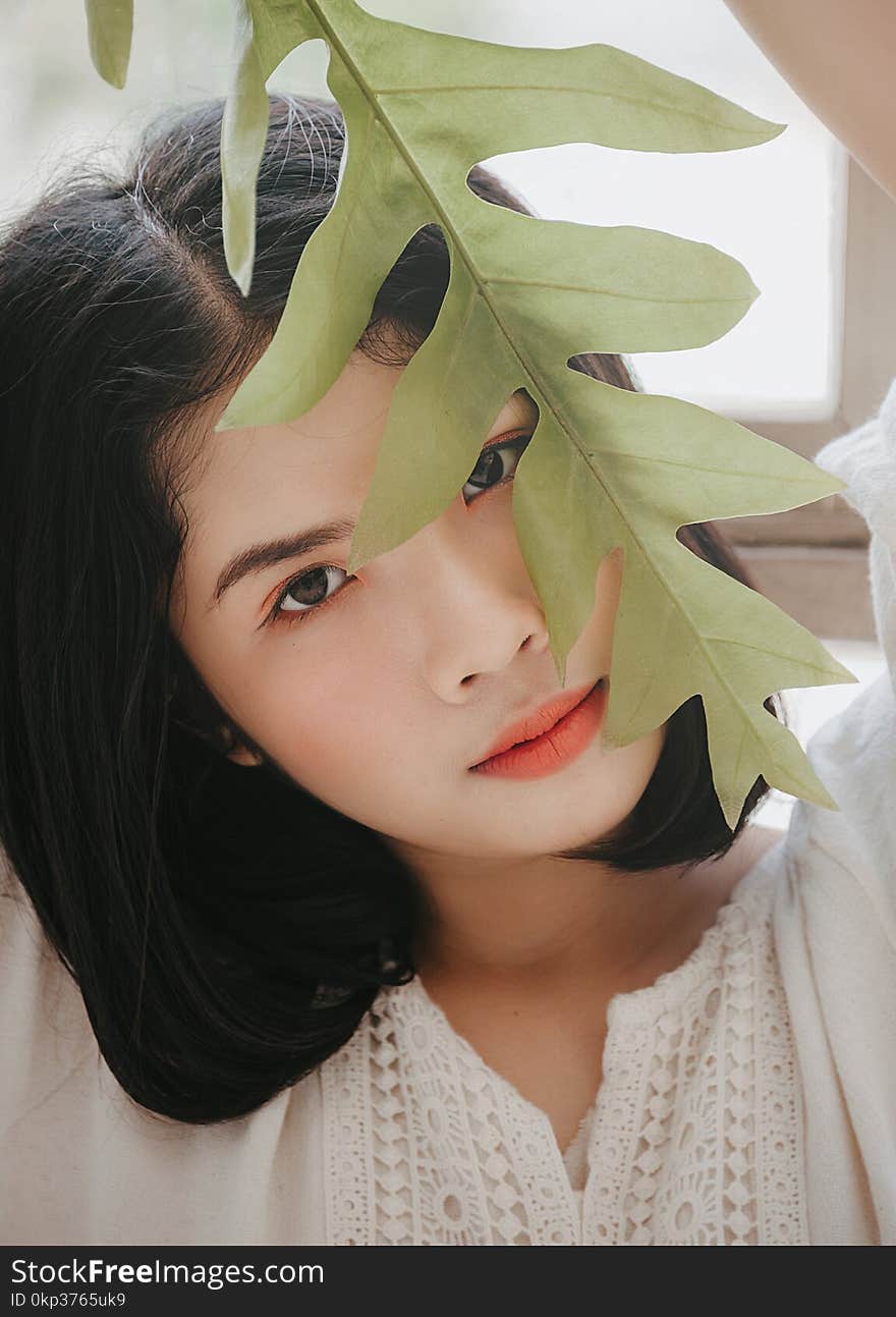 Close-Up Photography of a Woman Near Leaves