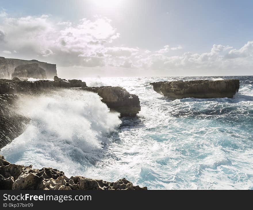 Brown Rock Formations Surrounded by Body of Water