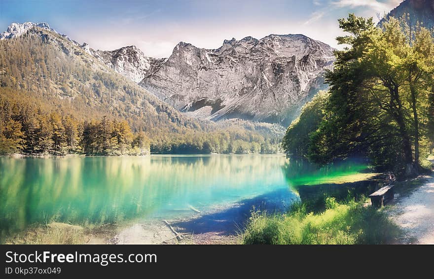 Landscape Photo of Calm Body Water Between Trees and Mountain