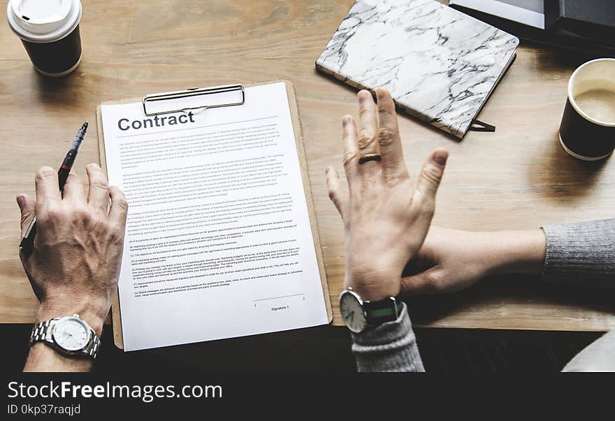 Person Holding Pen in Front Of Contract