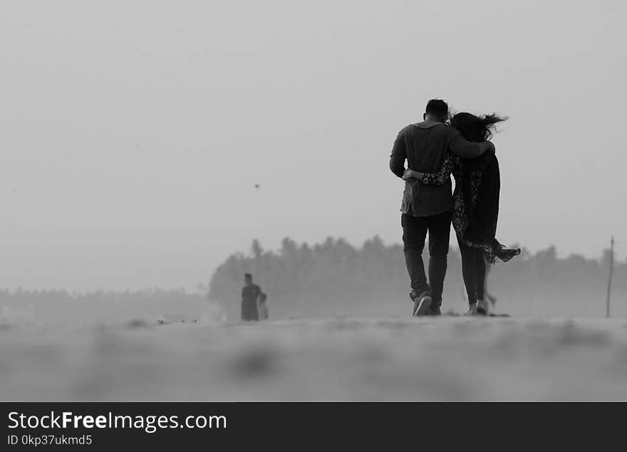 Grayscale Photography of Couple Walking on Ground