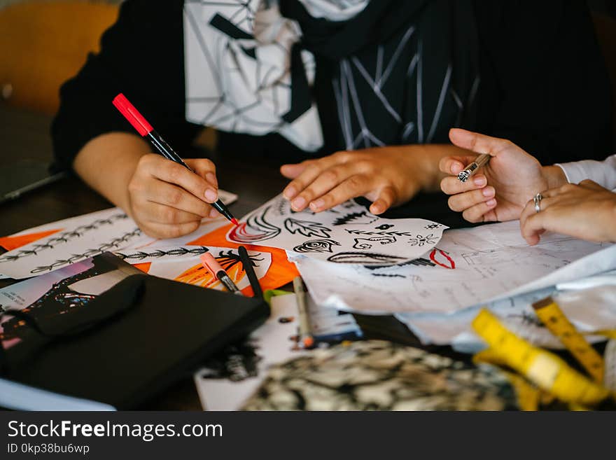 Person Writing on Paper on Top of Table