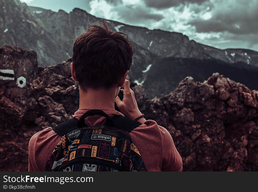 Man Taking Photos Of Mountains