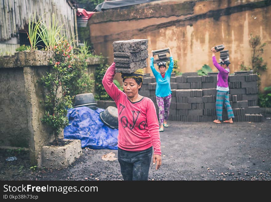 Photography of People Carrying Cinder Blocks