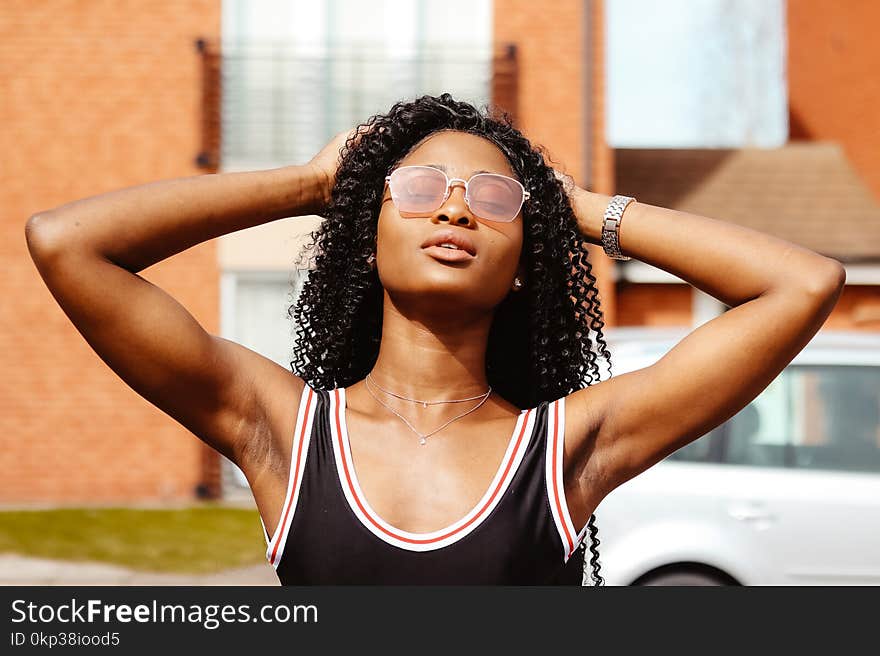 Photography Of Woman In Black Tank Top Holding Her Hair