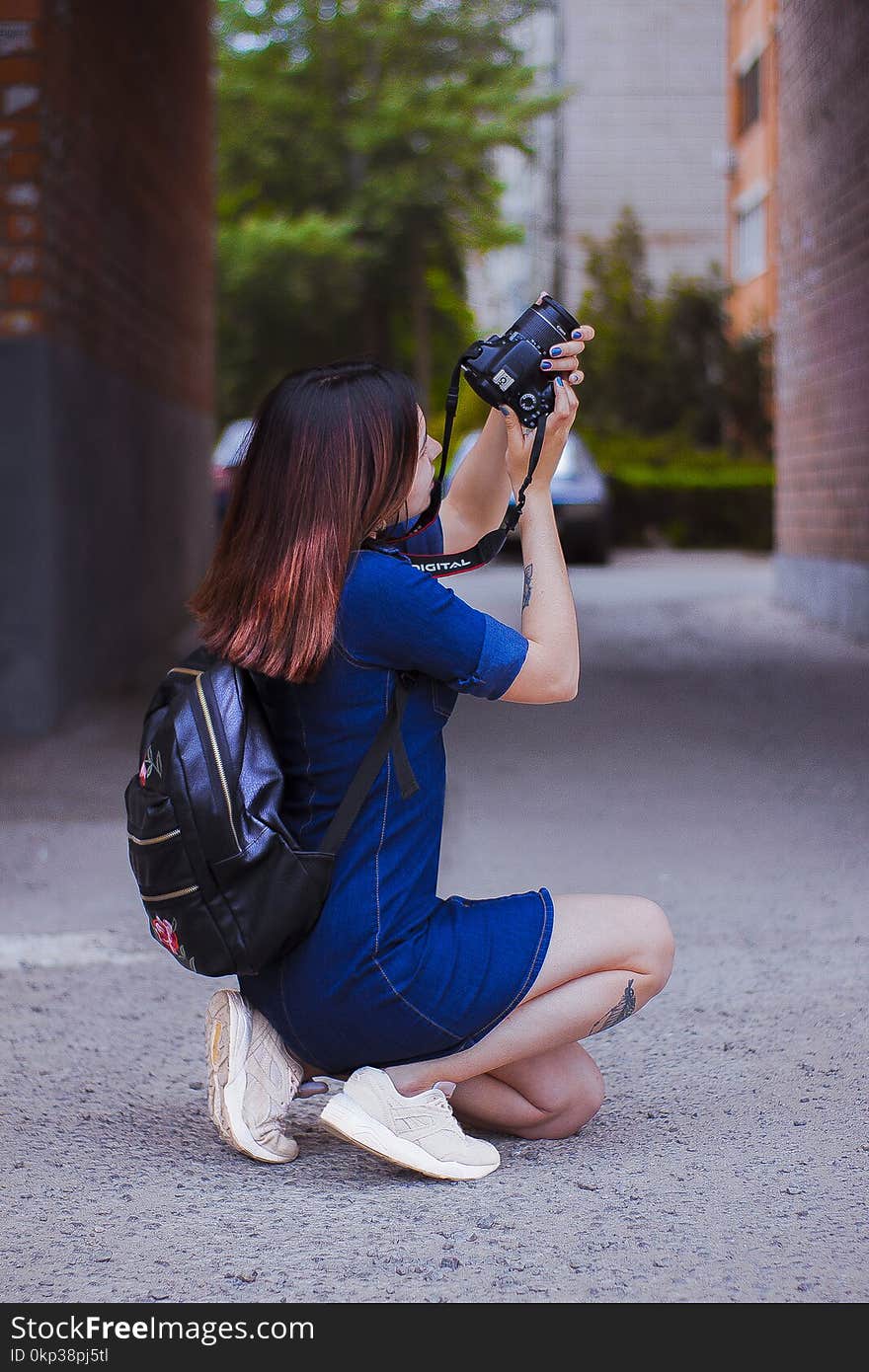 Photography of a Woman Kneeling While Taking a Picture