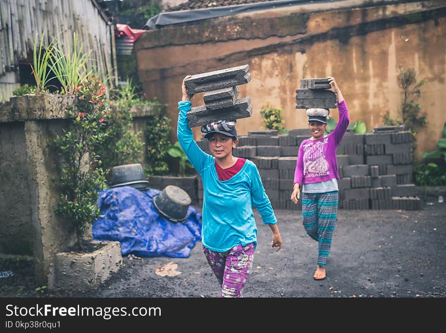 Photography of Women Carrying Cinder Blocks