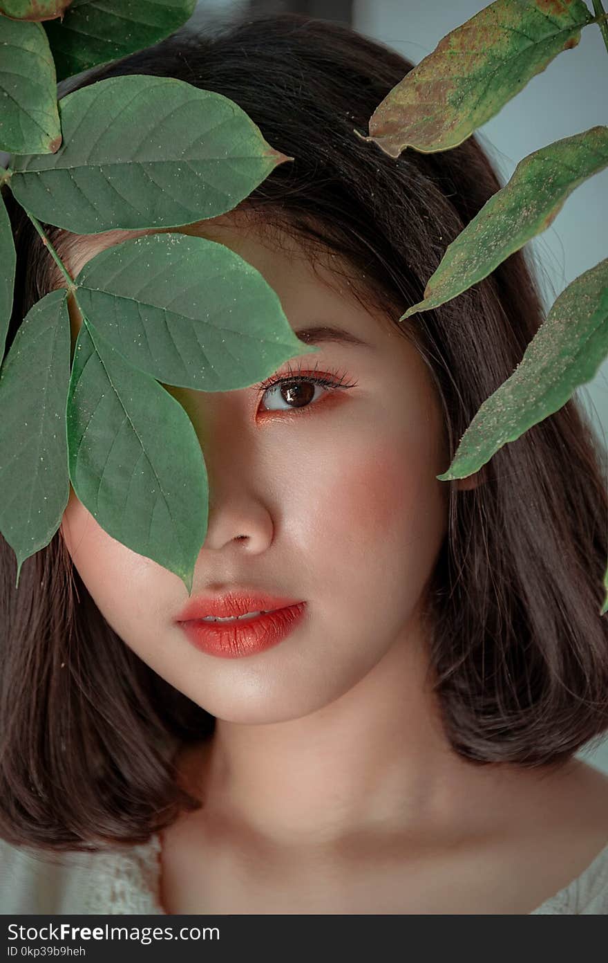 Close-Up Photography of a Woman Near Leaves