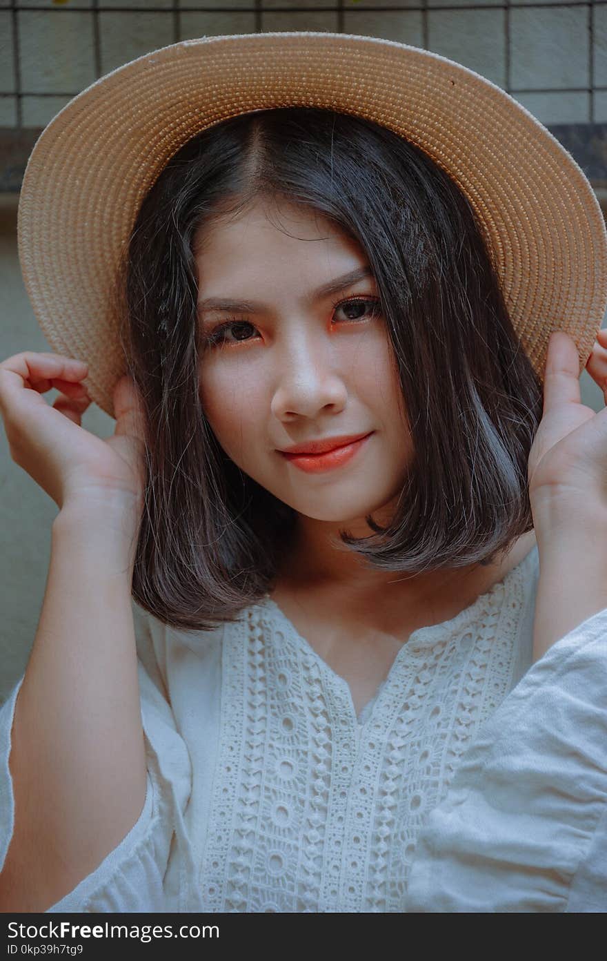 Woman Holding Brown Straw Hat