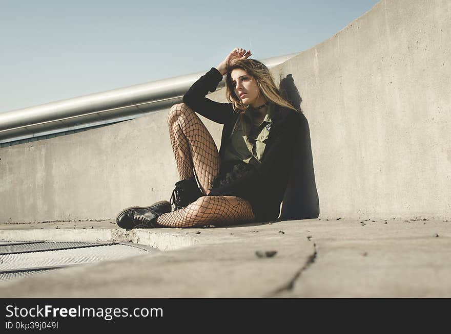 Photography of a Woman Leaning on a Wall