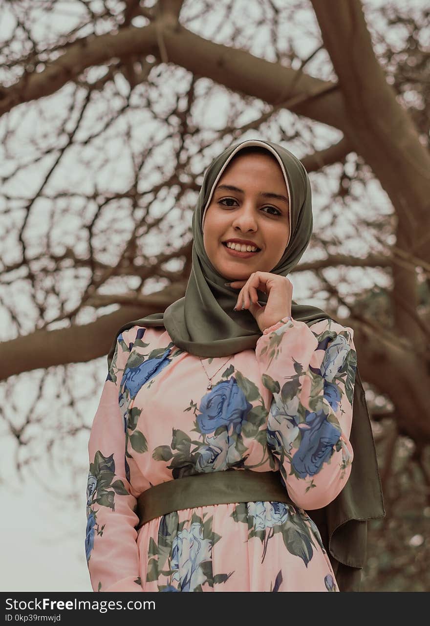 Woman in Floral Abaya Standing Near Tree