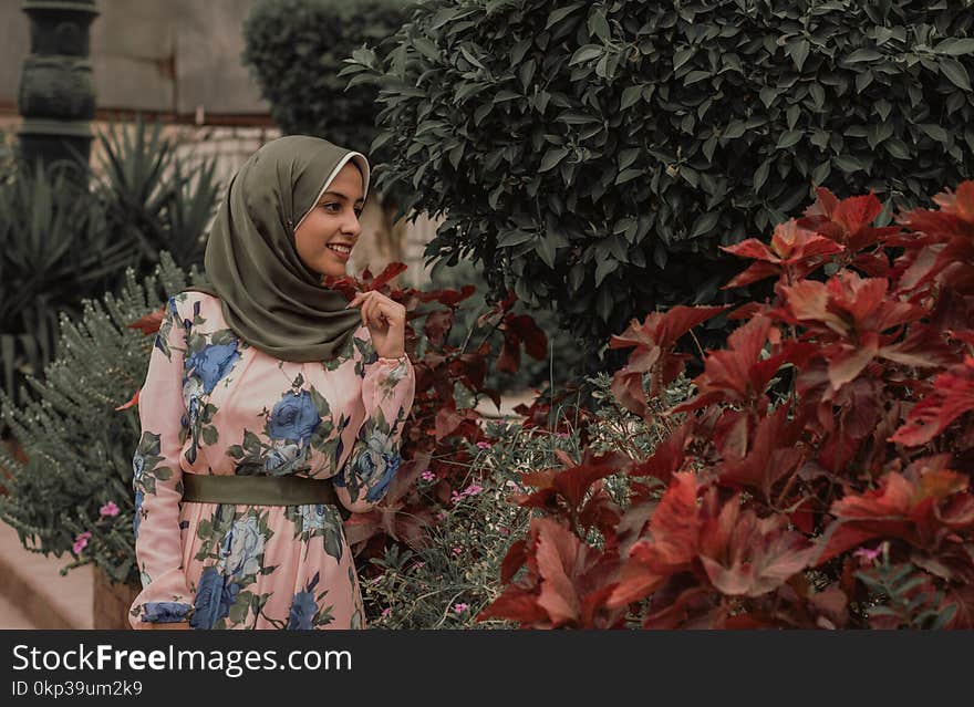 Woman Beside Red Petal Flowers