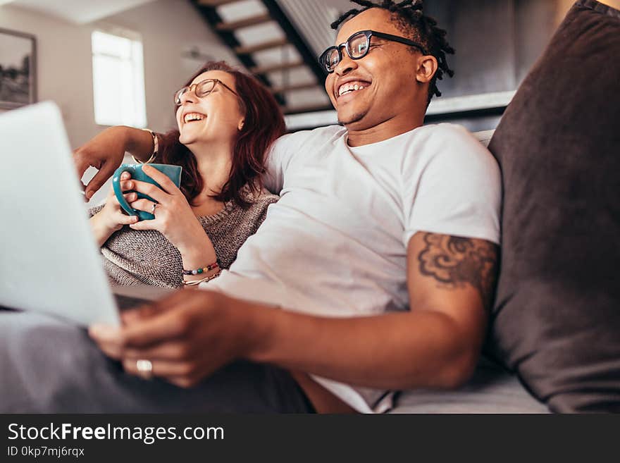 Cheerful multi-ethnic couple relaxing at home