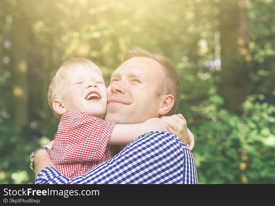 Father and son hugging and looking at the sun.