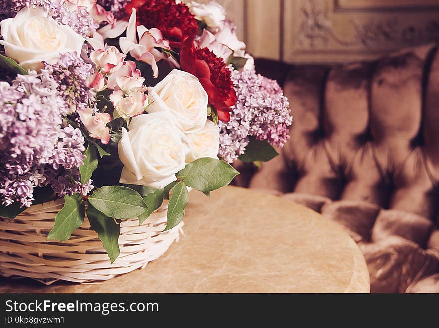 Bouquet of lilacs and red peonies on marble table in interior of the Baroque style