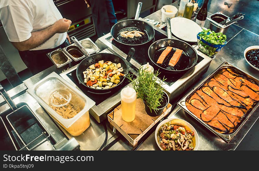 High-angle view of various fresh ingredients on the stove and the counter of a commercial kitchen in a trendy restaurant with fish specialties. High-angle view of various fresh ingredients on the stove and the counter of a commercial kitchen in a trendy restaurant with fish specialties