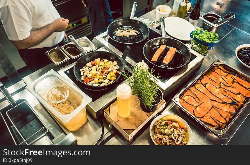 Various fresh ingredients on the stove of a commercial kitchen