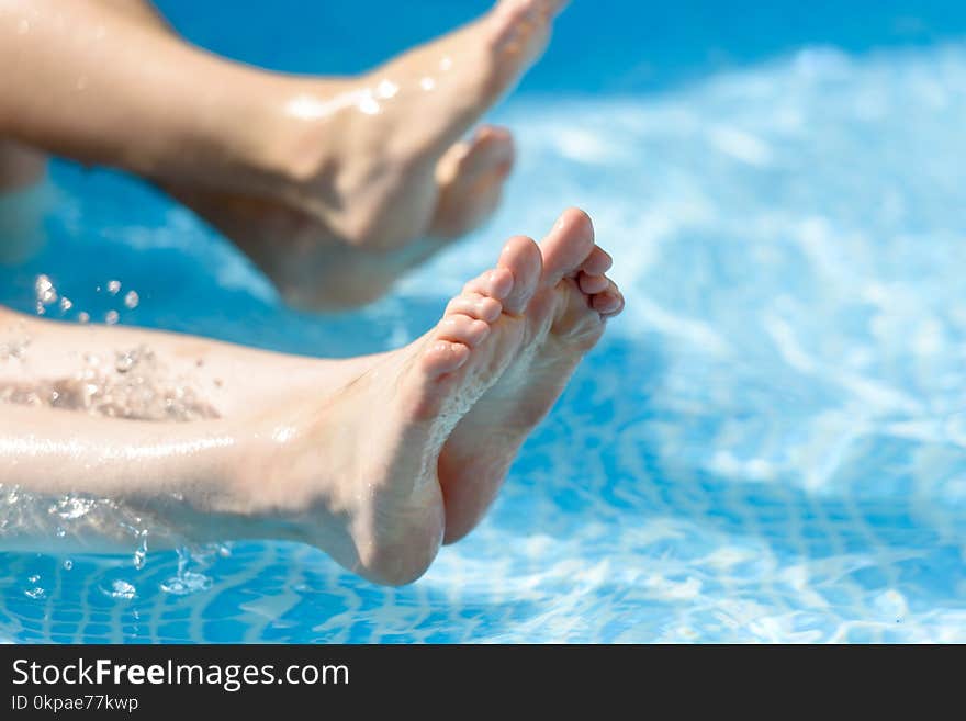 Legs in the pool splashing water.