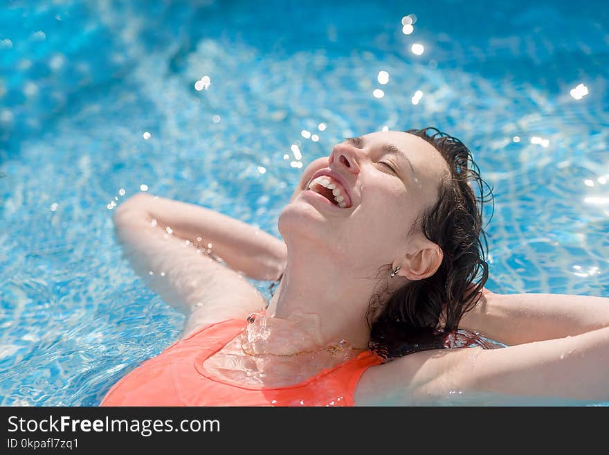 Happy girl swimming in the pool on a Sunny day, close-up.