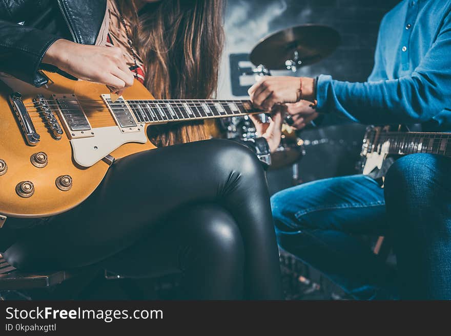 Guitar music teacher helping his student to play, closeup on the hands