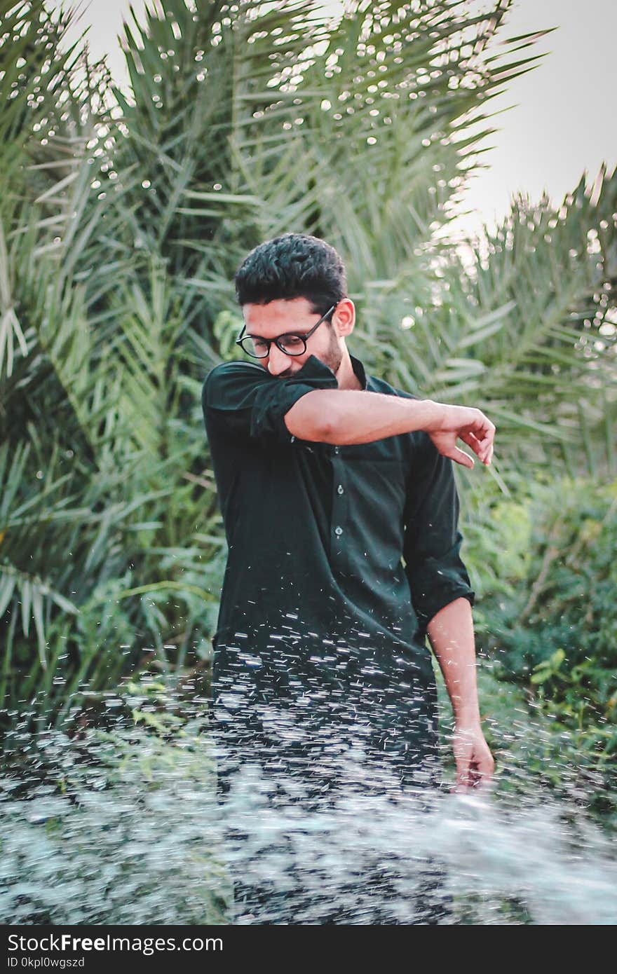 Man in Green Dress Shirt Near Palm Trees