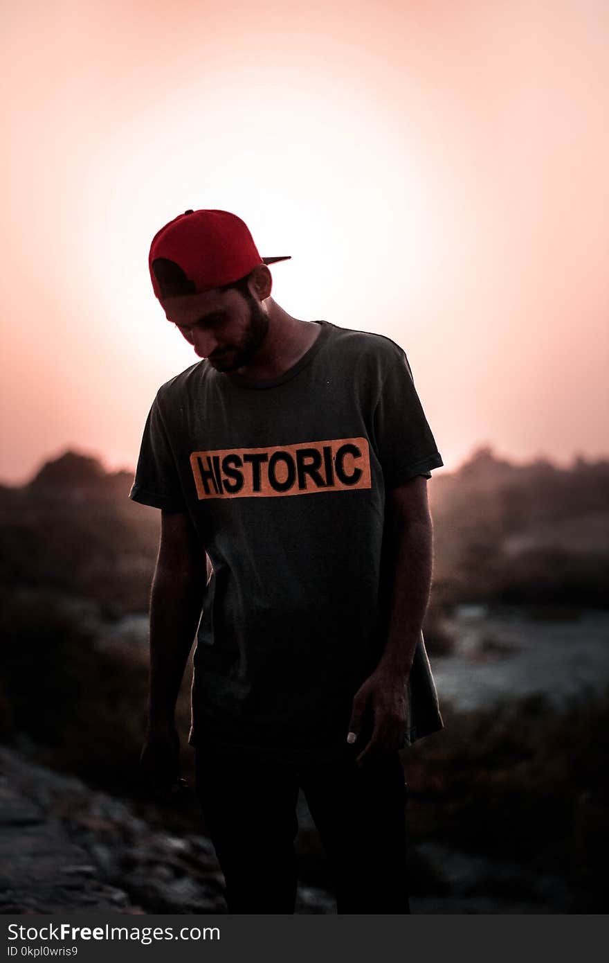 Man Wearing Gray T-shirt and Red Fitted Cap