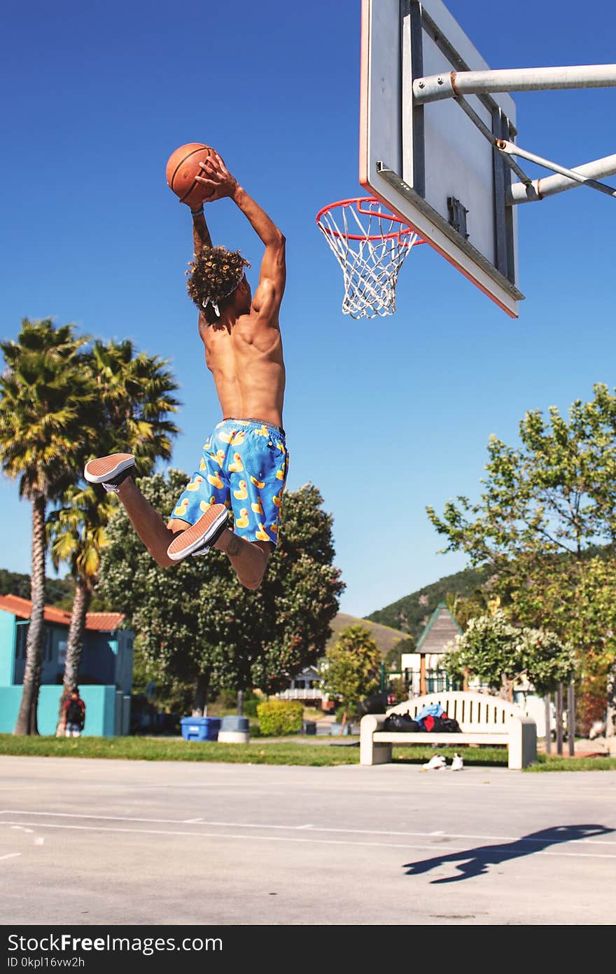 Man Wearing Blue and Yellow Shorts Playing Basketball