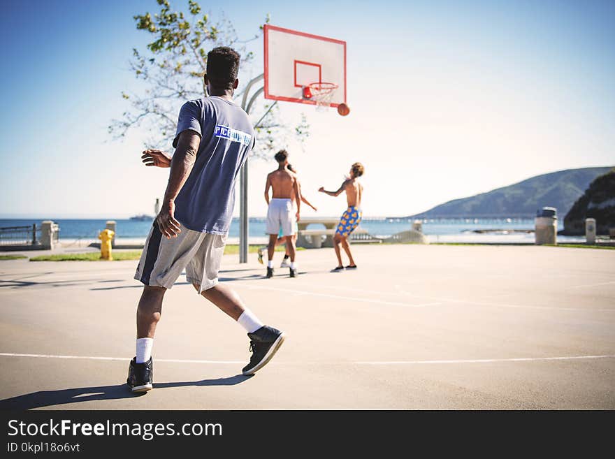 Four People Playing Basketball