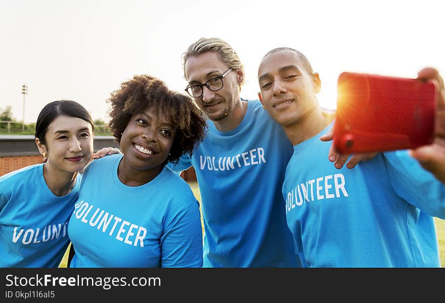 Group of People Wearing Blue Volunteer Shirts