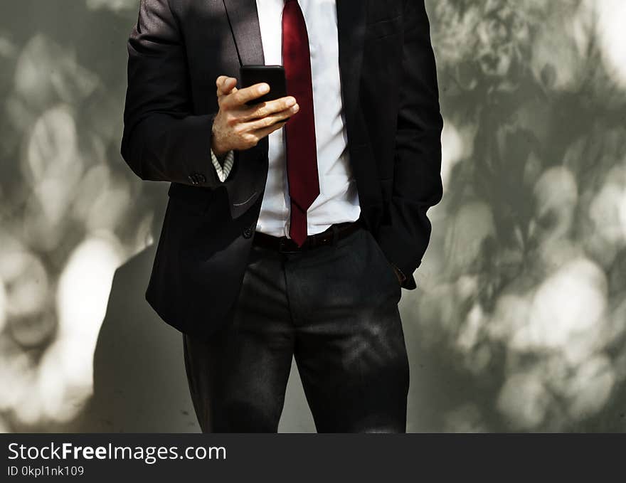 Man Wearing Black Tuxedo Holding Black Smartphone