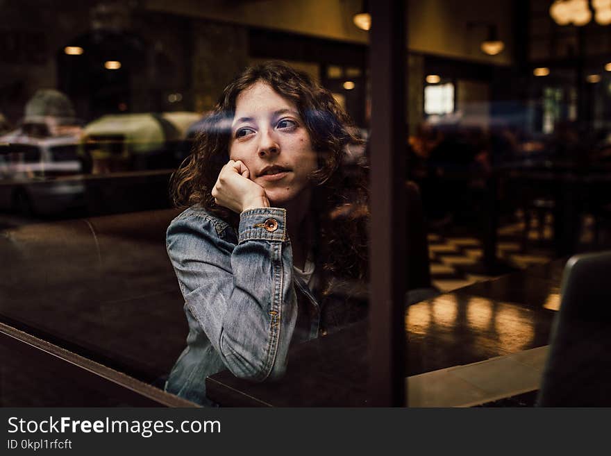 Woman Wearing Blue Denim Jacket Putting Her Right Arm on Her Cheek