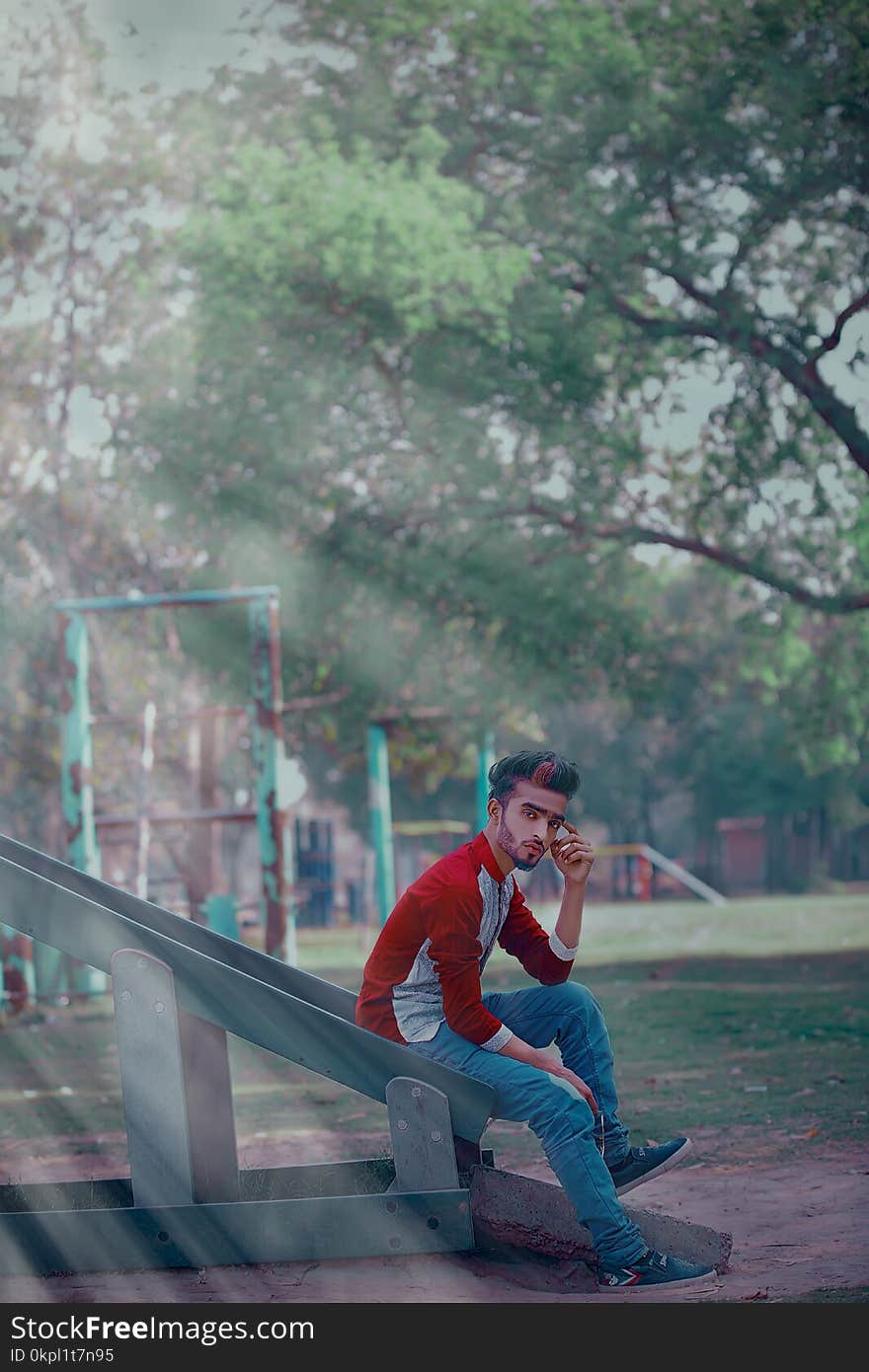 Man Wearing Red Long-sleeved Shirt Sitting On Slide