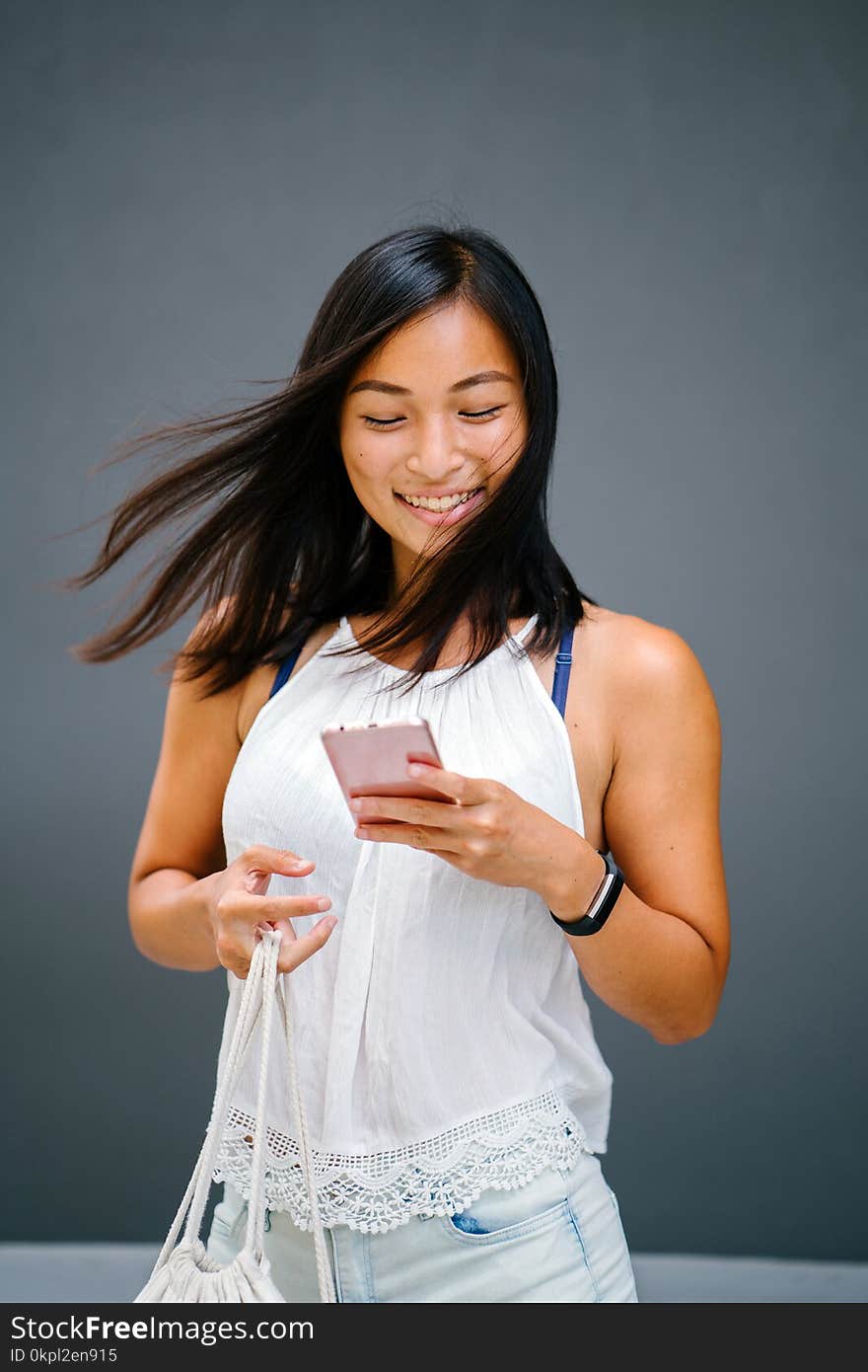 Woman Using A Phone While Carrying A Bag