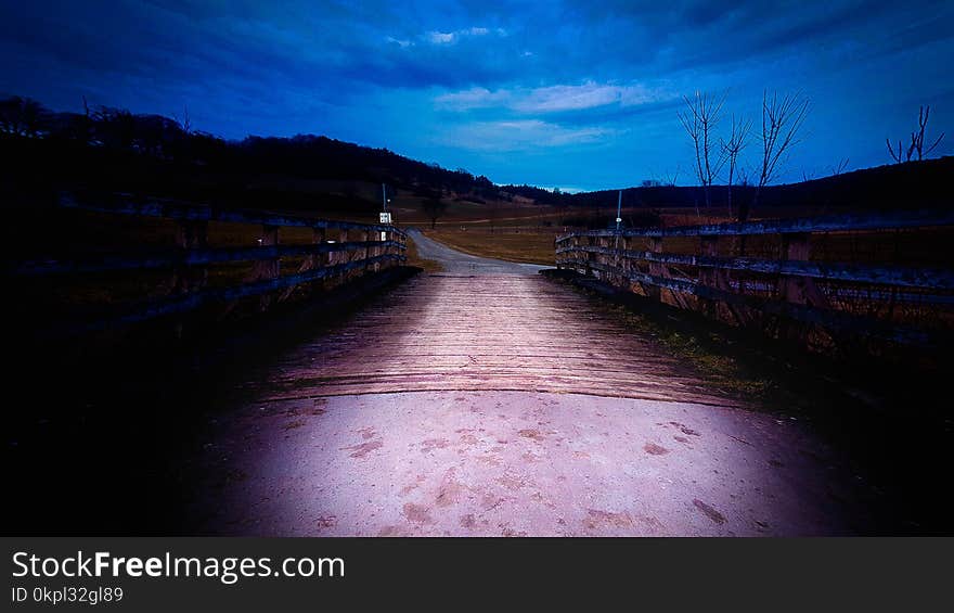 Brown Wooden Bridge Under Blue Cloudy Skies